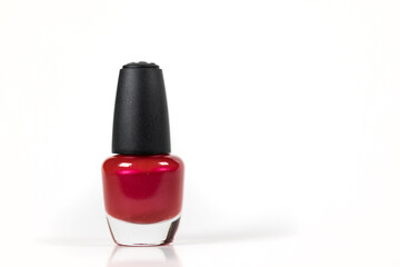 Bottle of red nail polish over a white background