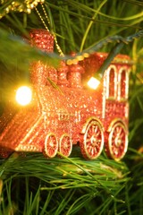 Vibrant train decoration hanging on a natural Christmas tree