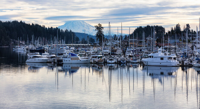 Marina in Gig Harbor with boats in the harbor with dramatic clouds and mt rainier 