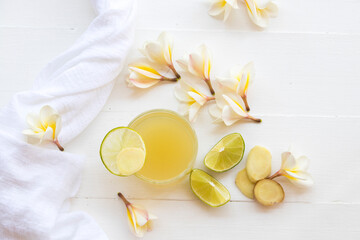 herbal healthy drinks ginger ,lemon cocktail water with flower frangipani decoration flat lay style on background white 