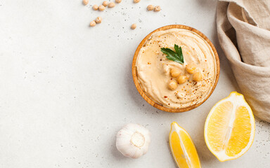 Hummus in a wooden plate with parsley. Dishes of chickpeas, a vegetarian dish. Copy space.