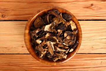Dried mushrooms in wooden bowl. Boletus badius.