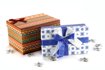 on a white background: one gift box with red, orange and green ornaments, another gift box white with a blue ornament and a blue bow