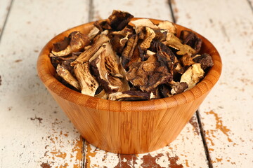 Dried mushrooms in wooden bowl. Boletus badius.
