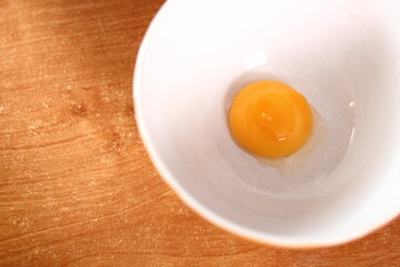 Separating egg yolk from white. Making mayonnaise with a wooden spoon.