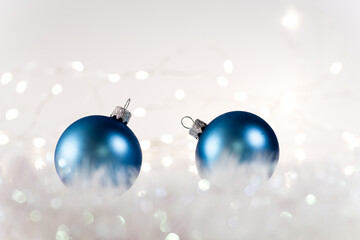 Fototapeta na wymiar Two blue matte Christmas balls on white artificial snow