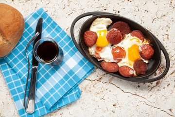 Fried eggs with sausage in pan