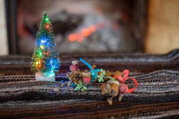 Christmas tree with lights and candles on the background of a stone fireplace with wood. cozy house waiting for christmas horizontal