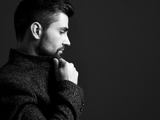 Black and white portrait in profile of serious bearded modern businessman in stylish tweed jacket...