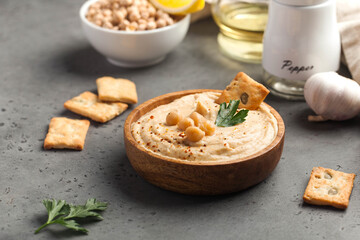 hummus in a wooden plate with parsley and croutons. Dishes of chickpeas, a vegetarian dish. Copy space.