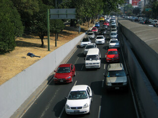 picture of a man laying on the street next to car