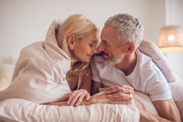 Middle-aged couple having romantic moment in bedroom