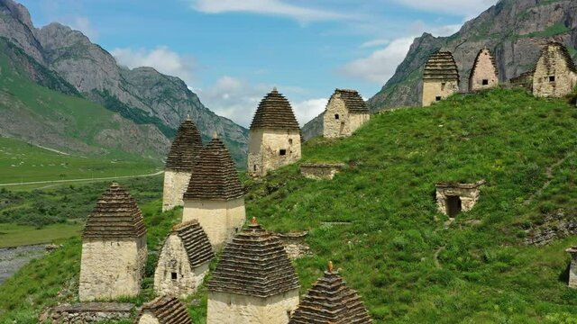 Aerial around view of Dead Town Dargavs In North Ossetia. The ancient cemetery of the Alans. Many small stone mausoleums, 4k