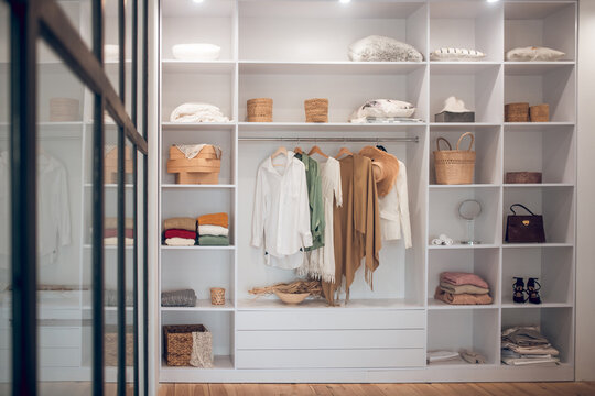 White wardrobe with clothes and shoes on the shelves