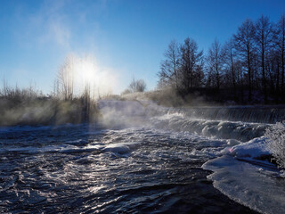 Stunning frozen icicles waterfall on a rocky mountain cliff on a winter day. The winter cascade is frozen in numerous white icicles. Waterfall falling past hundreds of icicles fantastic winter landsca