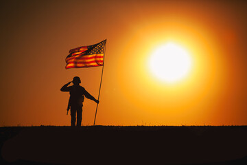 Silhouette of USA armed forces soldier, army infantryman or Marine Corps fighter saluting while...