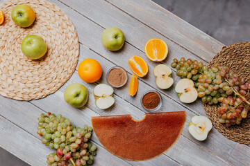 Grape fruit leather with fresh fruits on the wooden table. Round fruit leather. Healthy food. Apples, bananas, grape top view. Grape fruit without sugar.