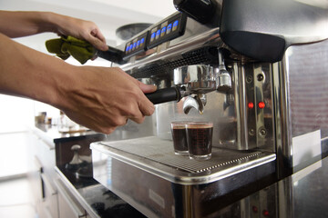 Close up the hand of barista make black coffee with a machine for service to the customer in the cafe shop