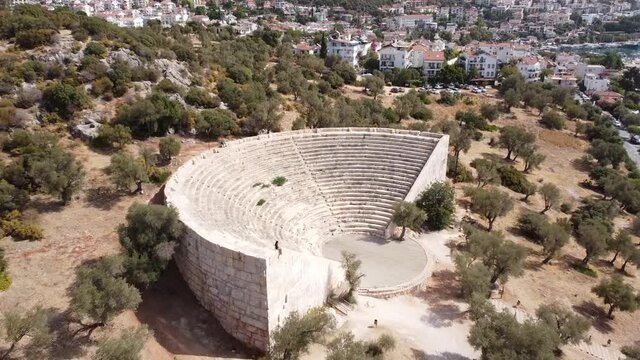 Woman looking the view from an antique Amphitheater in Kas, Turkey. Drone angle.