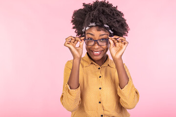 African american businesswoman holding glasses and smiling. Portrait of young woman looking at camera. Beautiful woman wearing yellow shirt.