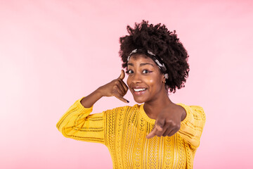 Fototapeta na wymiar Young beautiful woman doing talking on the telephone gesture and pointing to you. African american woman wearing casual clothes, smiling and looking at camera