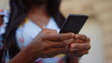 Unknown female person using mobile phone in city. Girl texting message outdoors