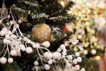 Christmas tree with decorations on blurred lights background. Toy ball on a branch, New Year celebration