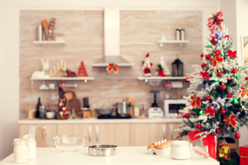 Ingredients for delicious cookies on christmas day on empty room. Kitchen on christmas day with nobody in the room decorated with x-mas tree and garlands