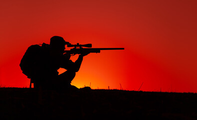 Commando team sniper, army special forces shooter aiming, shooting sniper rifle while sitting on sea or ocean shore during sunset. Coast or border guard soldier observing coastline with optical sight - obrazy, fototapety, plakaty