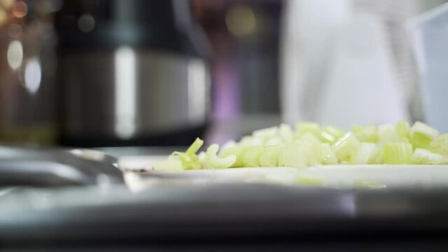 Cutting celery plant into small pieces for making juice