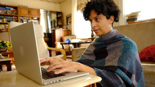 Home office working environment. Using laptop and working efficiently. Using technology and working at home productively. Young female adult study focused.