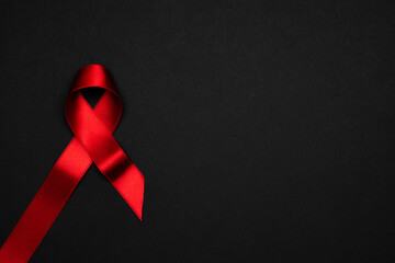 Aids day. Red ribbon symbol in hiv world day on dark background. Awareness aids and cancer. Healthcare and medical concept.