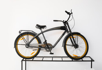 Fototapeta na wymiar Modern bicycle near light wall