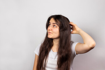 Fototapeta premium The girl scratches her head and thought about where to take the money before the salary. Credit and loan money, a banner with a place for text. Family budget planning, solving problems