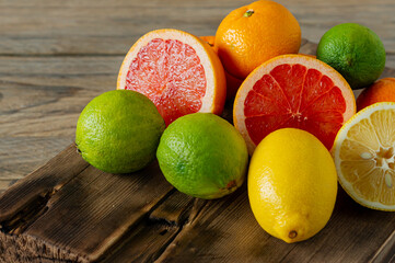 Halves of fresh citrus fruits on wooden background. Orange, grapefruit, lime, lemon, tangerine cut rings.