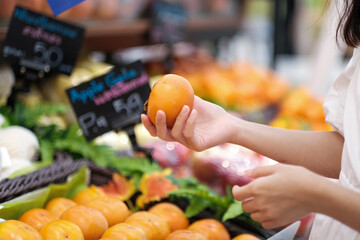 Woman shopping for Persimmon in supermarkets