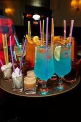 Multicolored alcoholic and non-alcoholic cocktails with ice and straws