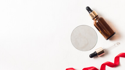 Obraz premium Flat lay composition with body and facial care products on a white background next to the red ribbon. Beauty flat lay with copy space. Image for beauty and spa salons