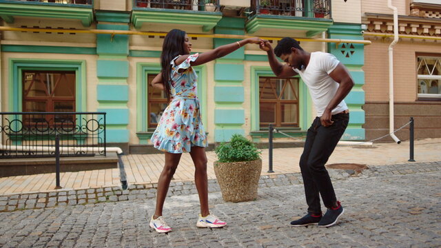 African Couple Dancing Jive In City. Sexy Afro Dancers Making Footwork On Street