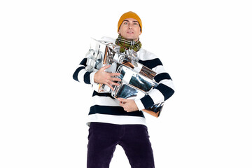 Handsome adult man in a striped jumper barely holds many gifts in silver packaging. Isolate on white. New Year advertising concept.