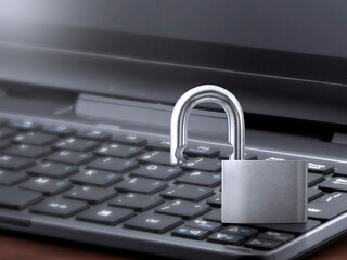 Computer security concept. Unlocked padlock on laptop keyboard. Symbol of safe. Toned soft focus picture
