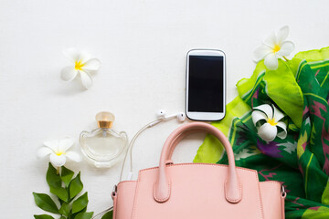 pink hand bag  ,mobile phone ,perfume  with green scarf collection colorful fashion of lifestyle woman relaxation and white flower frangipani on background white