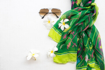 sunglasses with  green scarf collection colorful fashion of lifestyle woman relaxation and white flower frangipani on background white