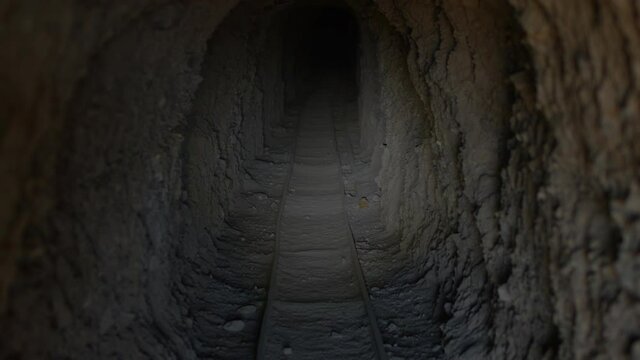 Inside Abandoned Mine with Ore Cart Track - Lit with Flashlight - Shallow Depth of Field