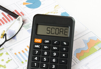 Calculator with text on the display Score it is on the financial charts with eyeglasses