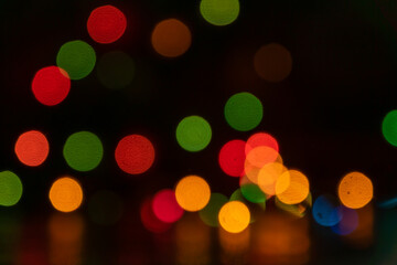 Fototapeta premium Festive multicolored bokeh background. Blurred lights of led garland. Copy space