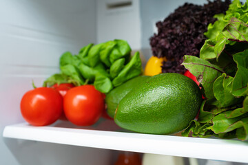Fridge shelf full of fresh vegetables close up