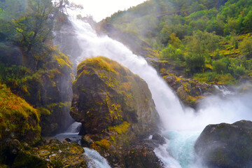 Fototapeta na wymiar Beautiful waterfall in the Jostedalsbreen National Park in Norway. Pathway to Briksdal or Briksdalsbreen glacier in Olden. 