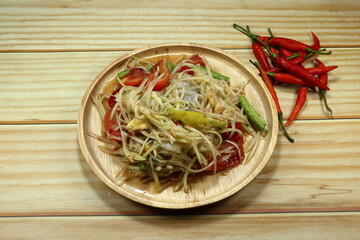 Som Tam, Spicy papaya salad seasoning with pickled fish sauce on the wooden plate. Popular local street food menu in Asian restaurant. 