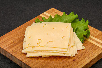 Sliced yellow cheese over board